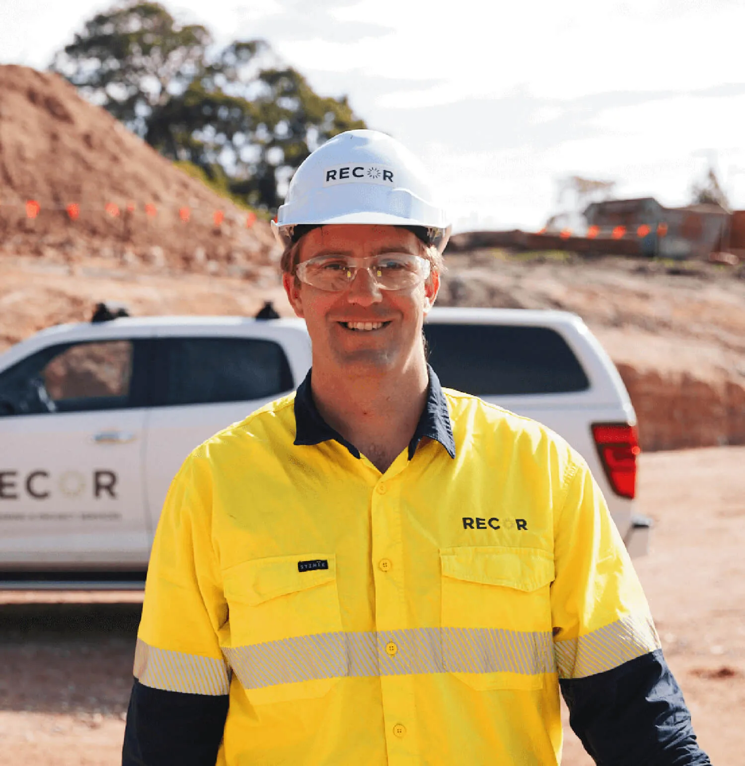 A man in hi vis in front of a ute