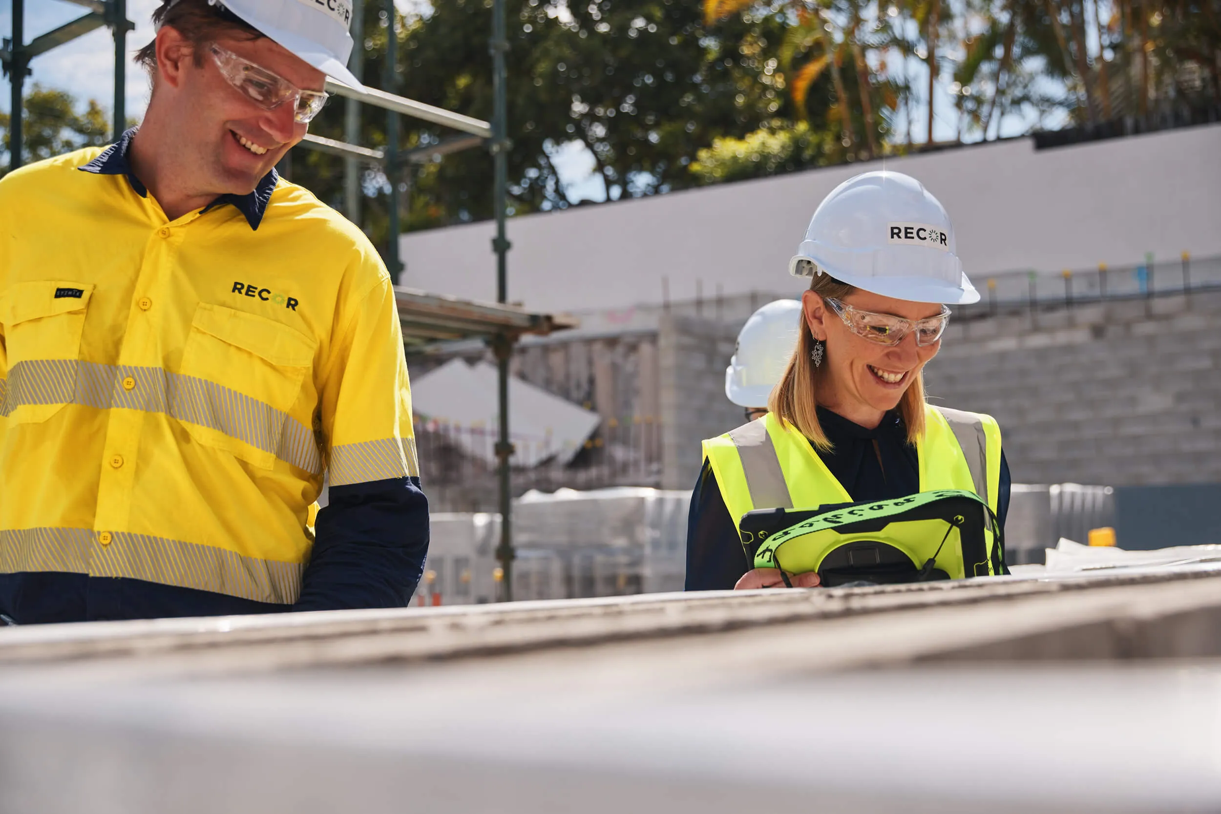 a man and a woman wearing hard hats and safety vests