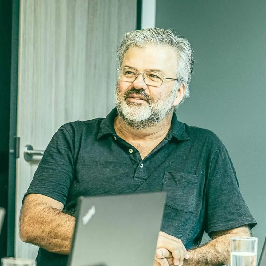 a man sitting at a table with a laptop in front of him